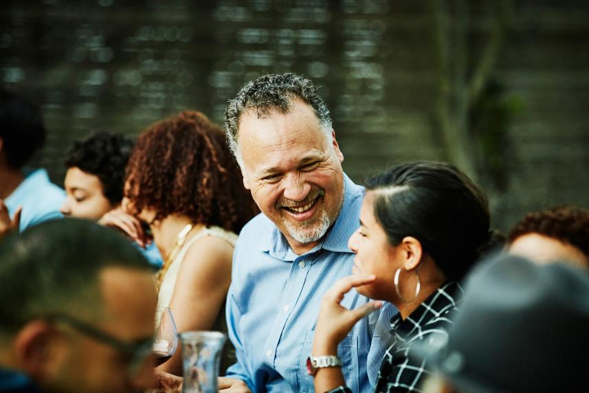 Man laughing in a social gathering setting