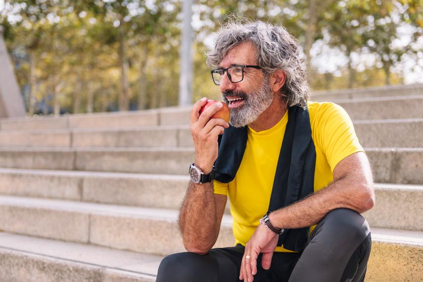 Man sitting on steps, eating an apple