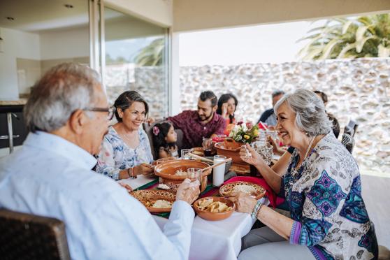 A family having a meal outside at a long table