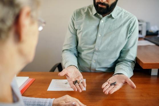 Man presenting hearing aid options to a patient
